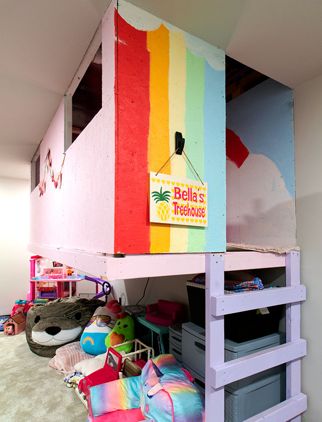 Colorful play fort made out of wood located inside of playroom