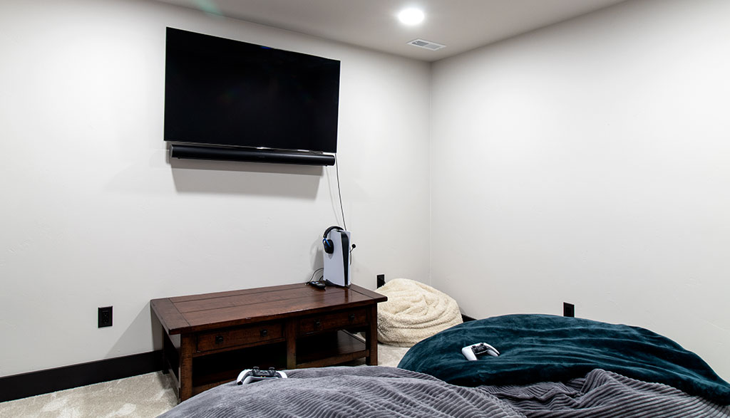 Light colored room with mounted TV and large bag chairs for gaming