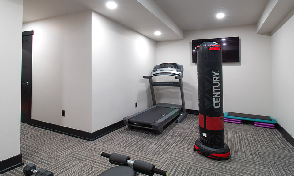 Photo of basement gym with treadmill and other gym equipment