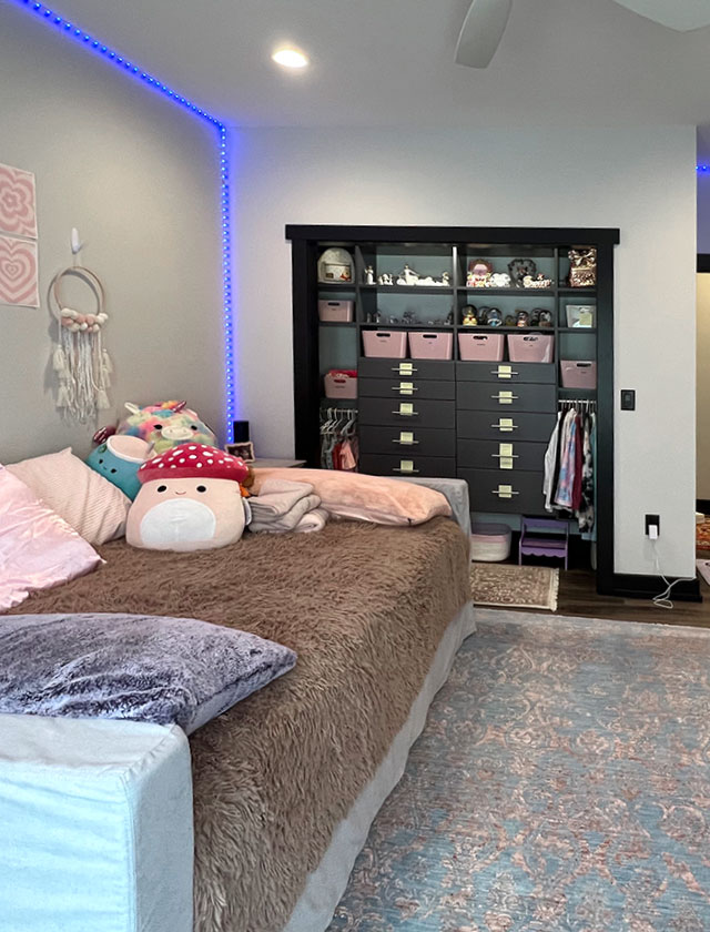 Photo of bedroom with light gray walls, an organized closet with a built-in, and a bed